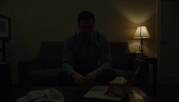 A man sitting alone in a dimly lit room